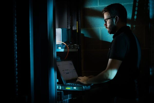 FUTERA - Employee working on laptop in server room - Cyber Security